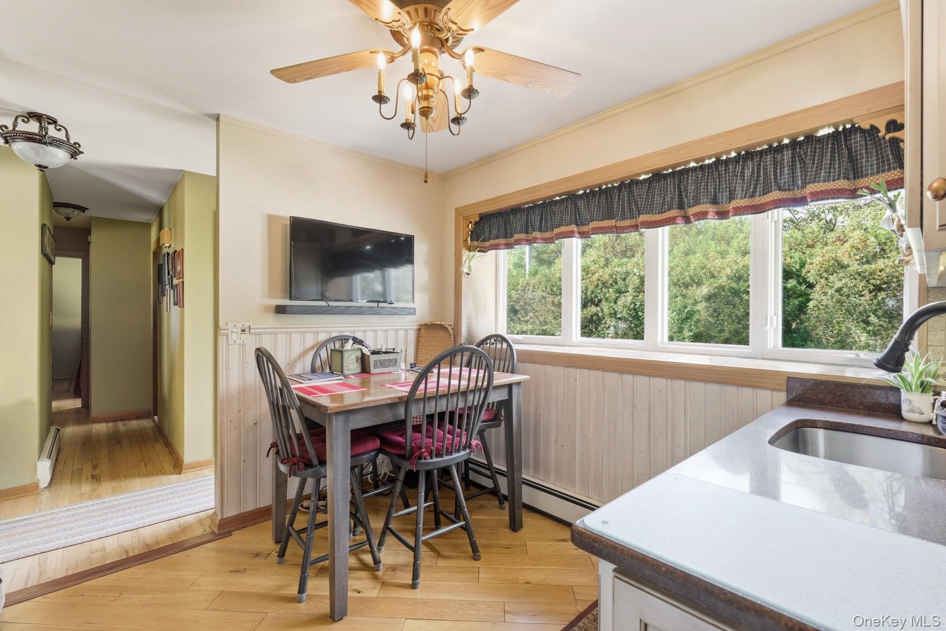 347 Wading River Road Manorville, NY 11949 - Photo 8 of 30 Dining room featuring light wood finished floors, ornamental molding, and a baseboard heating unit