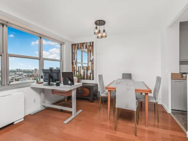 a view of a workspace with furniture and a window