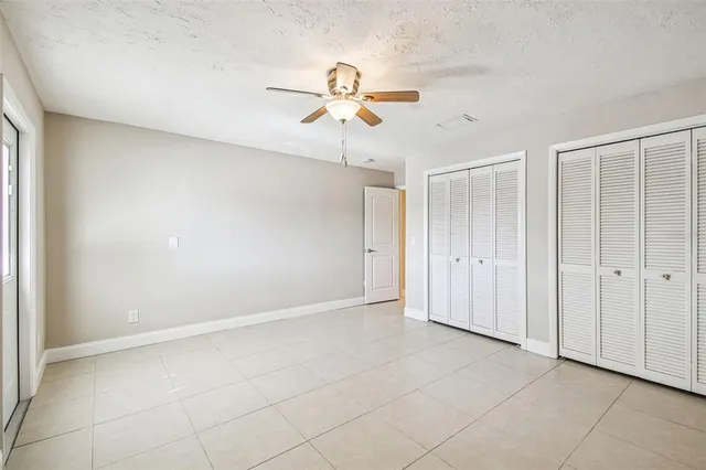 a view of an empty room with a chandelier fan