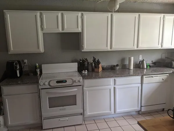a kitchen with white cabinets and white appliances