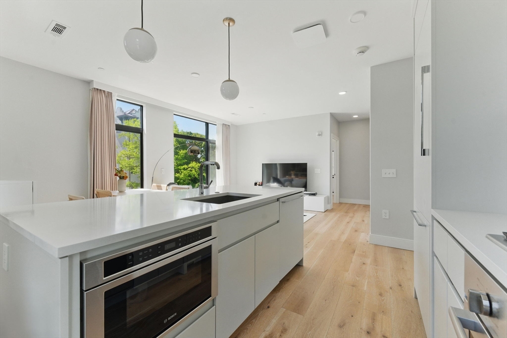 191 Washington Street, Unit 524 Boston, MA 02135 - Photo 12 of 42 a large kitchen with a large counter space a sink and appliances