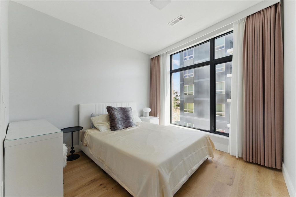 191 Washington Street, Unit 524 Boston, MA 02135 - Photo 14 of 42 a bedroom with a large bed and a large window