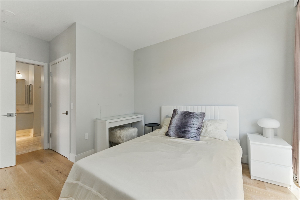 191 Washington Street, Unit 524 Boston, MA 02135 - Photo 15 of 42 a bedroom with a bed and a night stand