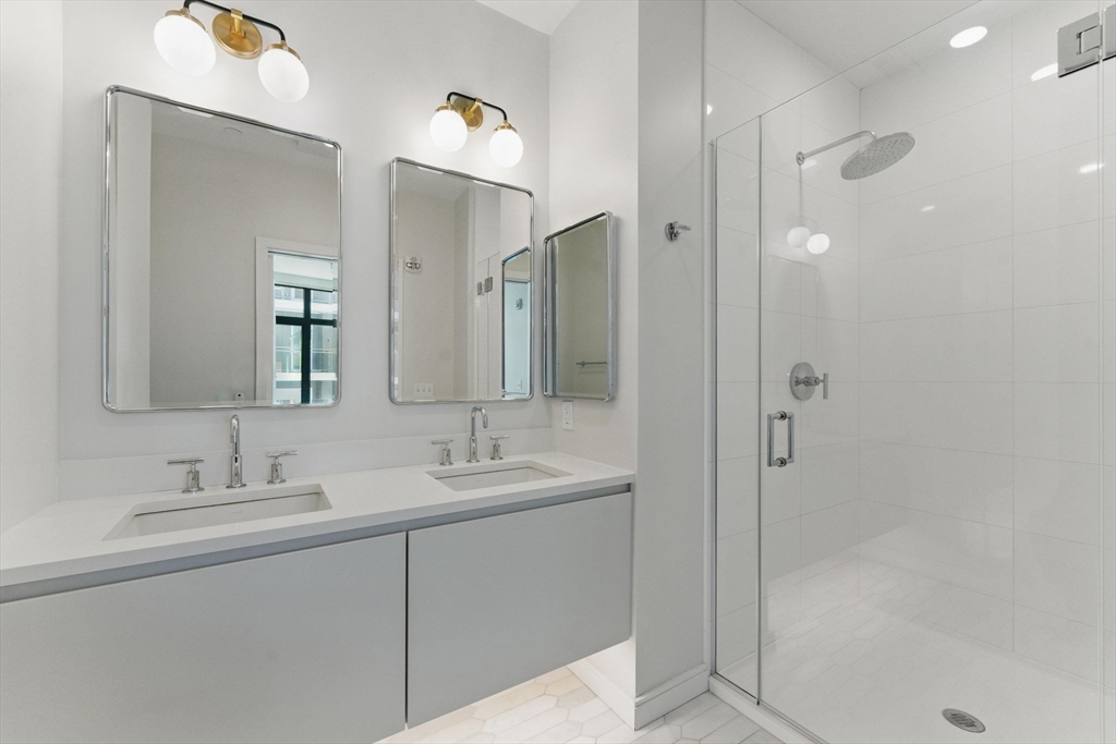 191 Washington Street, Unit 524 Boston, MA 02135 - Photo 18 of 42 a bathroom with a double vanity sink mirror and shower