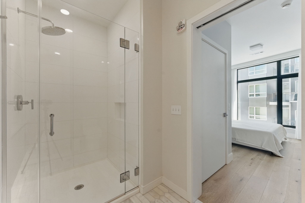 191 Washington Street, Unit 524 Boston, MA 02135 - Photo 20 of 42 a bathroom with a tub shower and sink