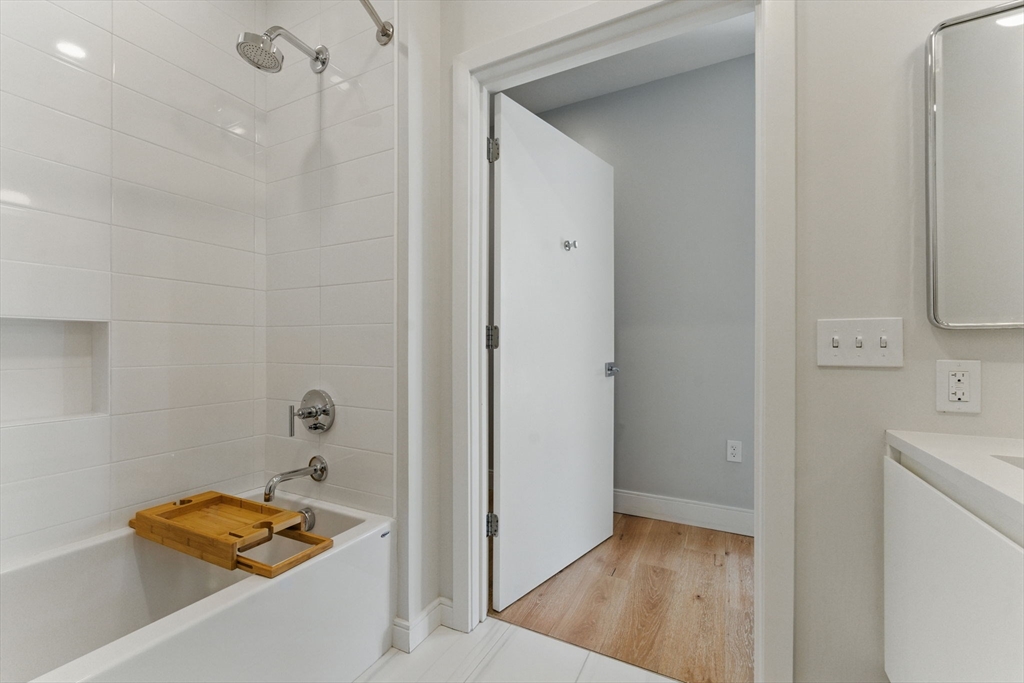 191 Washington Street, Unit 524 Boston, MA 02135 - Photo 26 of 42 a view of room with walk in closet and wooden floor