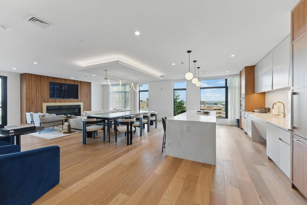 191 Washington Street, Unit 524 Boston, MA 02135 - Photo 32 of 42 a large living room with stainless steel appliances granite countertop a couch and a view of living room