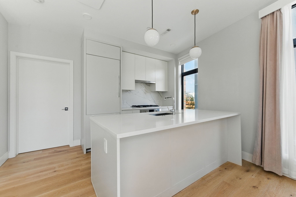 191 Washington Street, Unit 524 Boston, MA 02135 - Photo 8 of 42 a kitchen with a sink a counter space cabinets and appliances