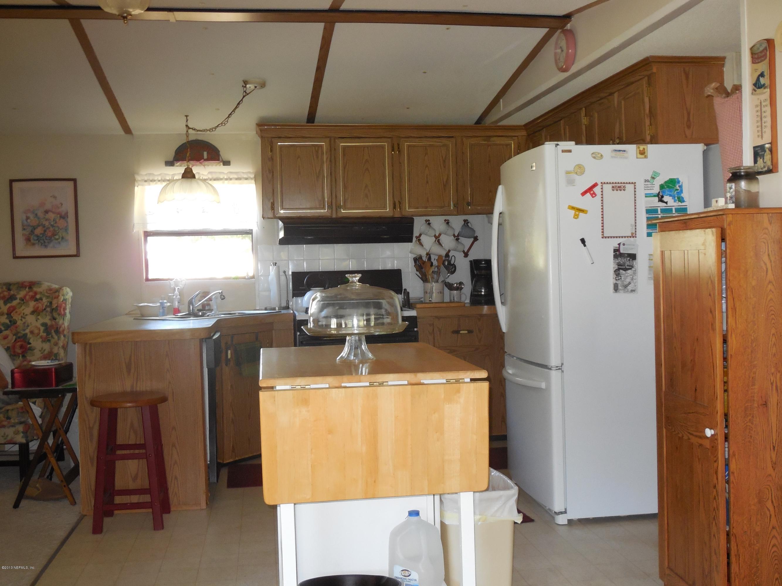 105 Ketner Road Welaka, FL 32112 - Photo 11 of 34 a kitchen with a refrigerator a stove a sink and a dining table