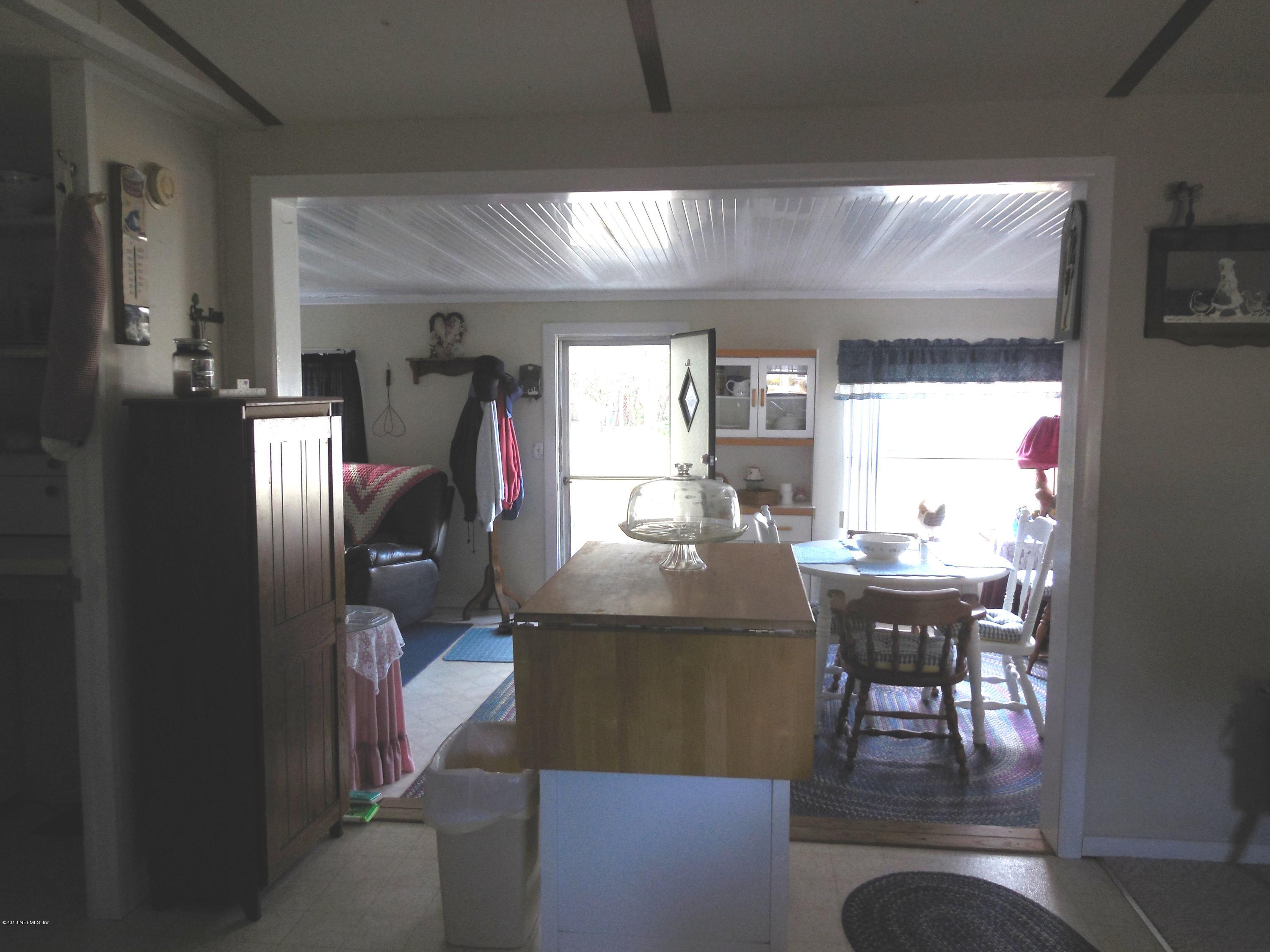 105 Ketner Road Welaka, FL 32112 - Photo 13 of 34 a living room with chairs dining table and a large window