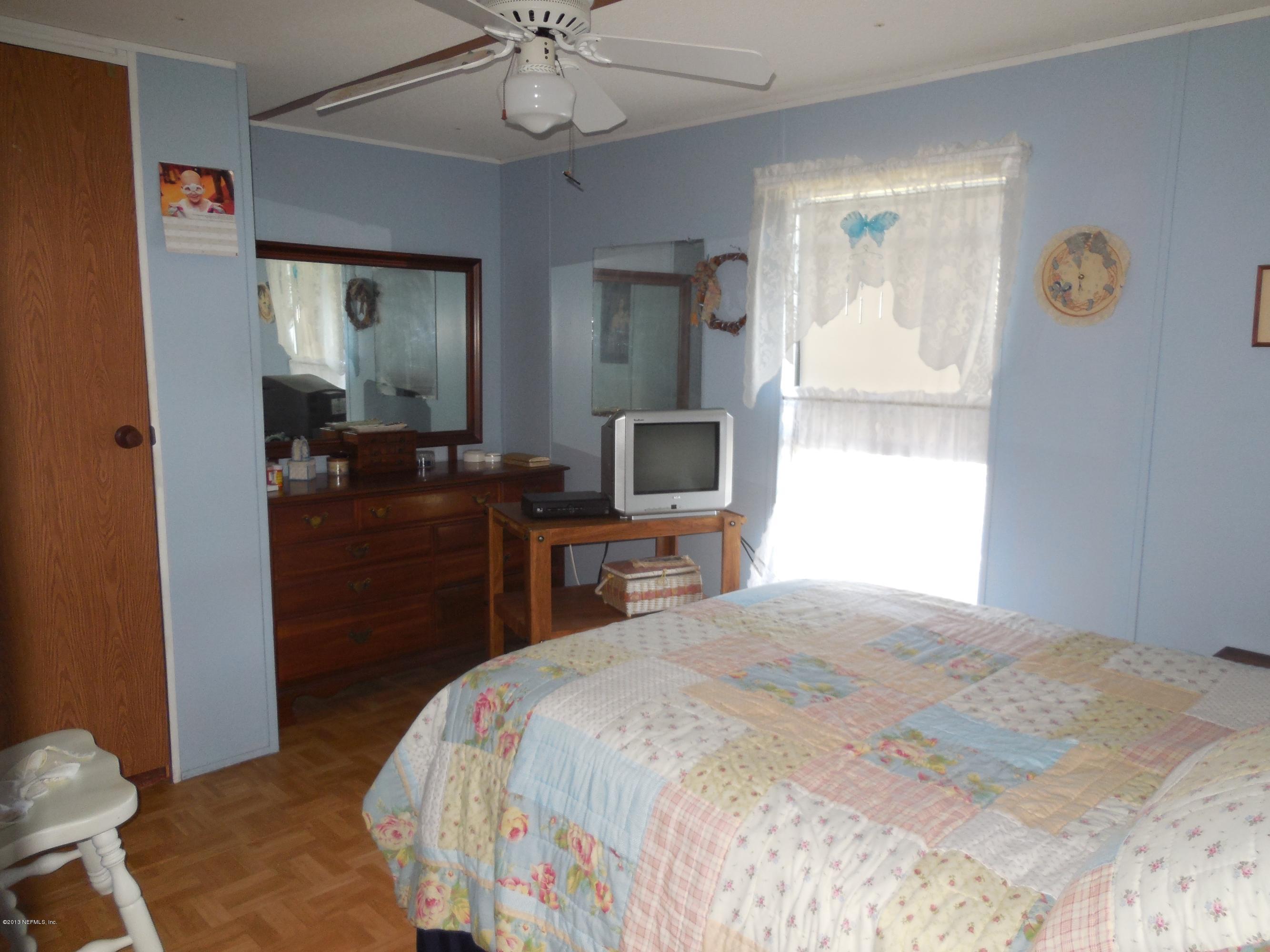 105 Ketner Road Welaka, FL 32112 - Photo 21 of 34 a bedroom with a bed and a chandelier