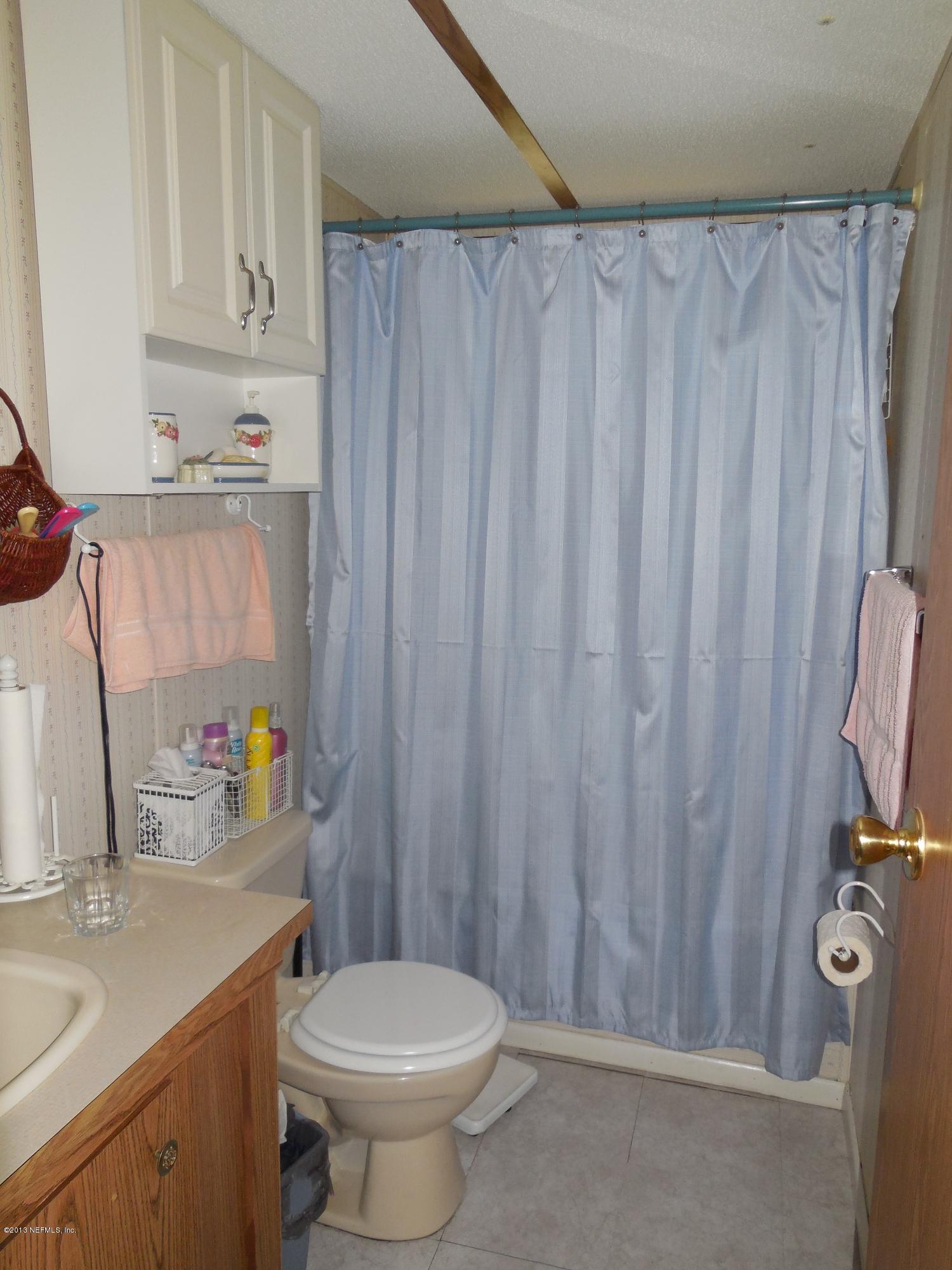 105 Ketner Road Welaka, FL 32112 - Photo 24 of 34 a bathroom with a sink a toilet and shower curtain
