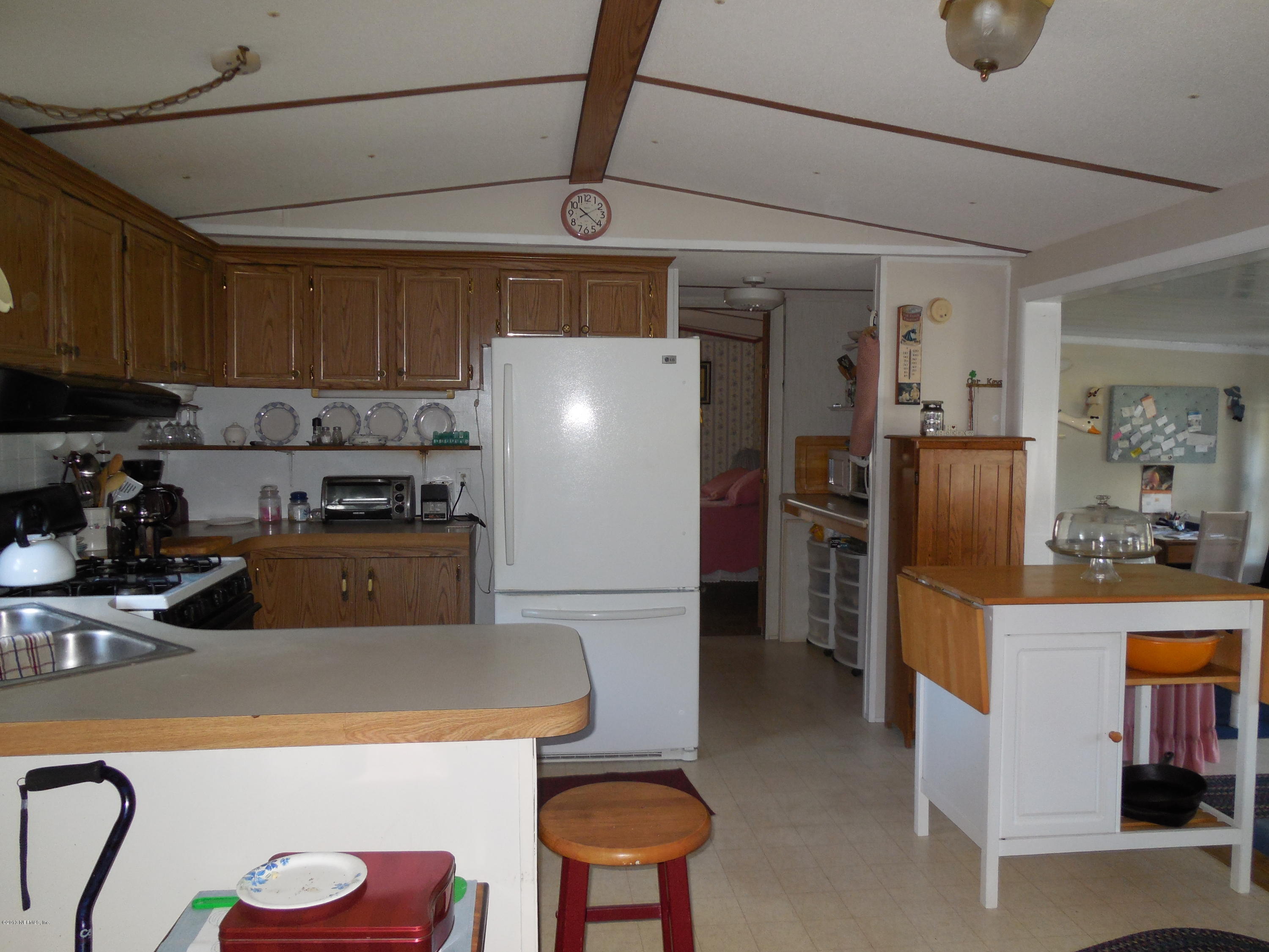 105 Ketner Road Welaka, FL 32112 - Photo 8 of 34 a kitchen with stainless steel appliances granite countertop a refrigerator and a stove top oven