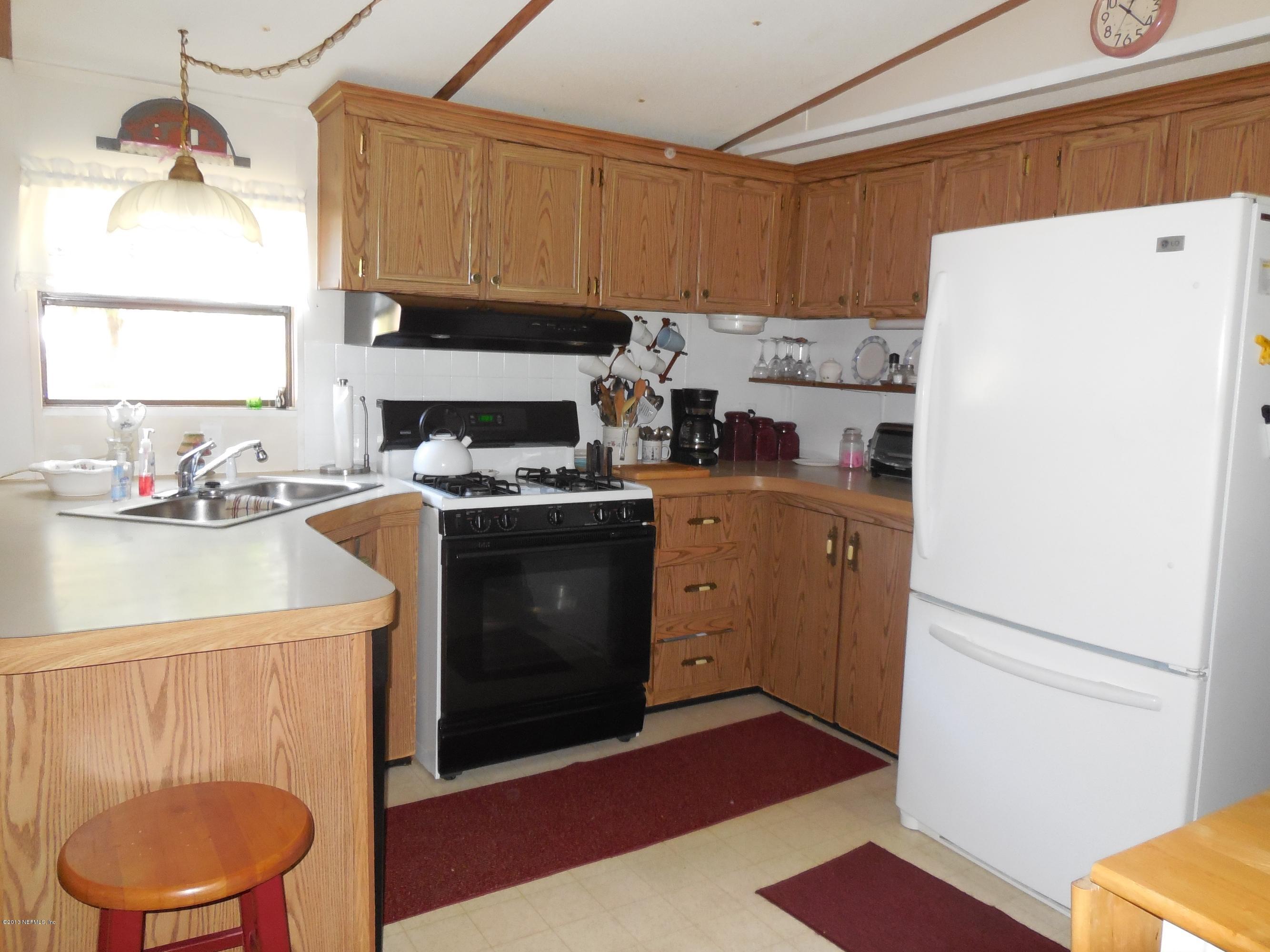 105 Ketner Road Welaka, FL 32112 - Photo 9 of 34 a kitchen with a stove a refrigerator and a sink