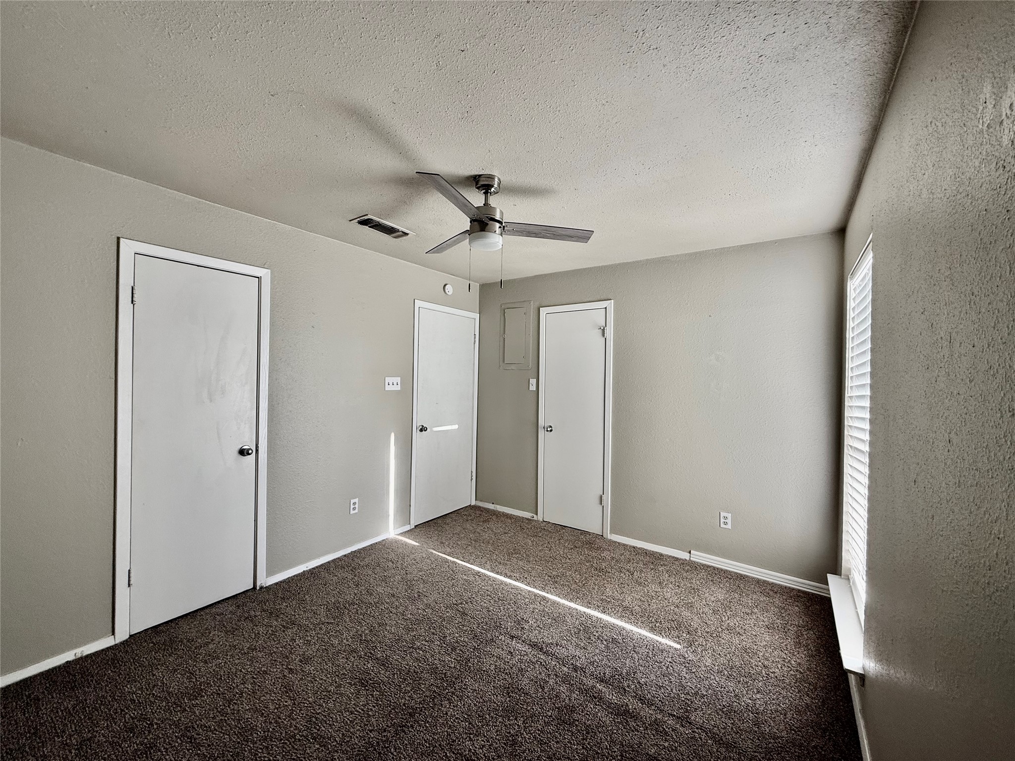 2018 West Rundberg Lane, Unit 6A Austin, TX 78758 - Photo 15 of 17 Unfurnished bedroom with carpet, a ceiling fan, and a textured ceiling