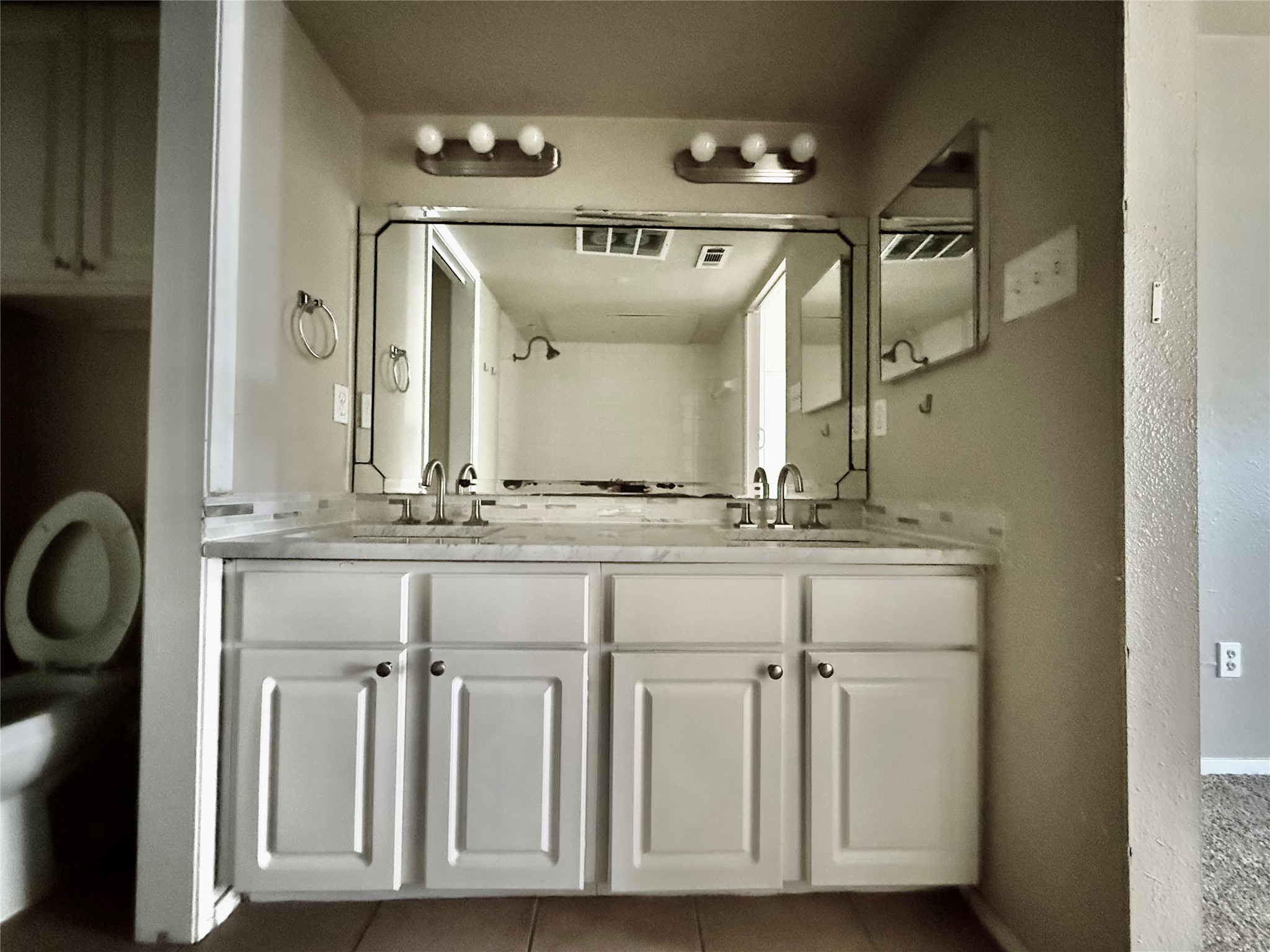 2018 West Rundberg Lane, Unit 6A Austin, TX 78758 - Photo 16 of 17 Bathroom with double vanity, dark tile patterned flooring, and a textured wall