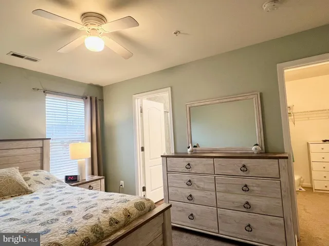 a bedroom with a bed and a mirror on dresser