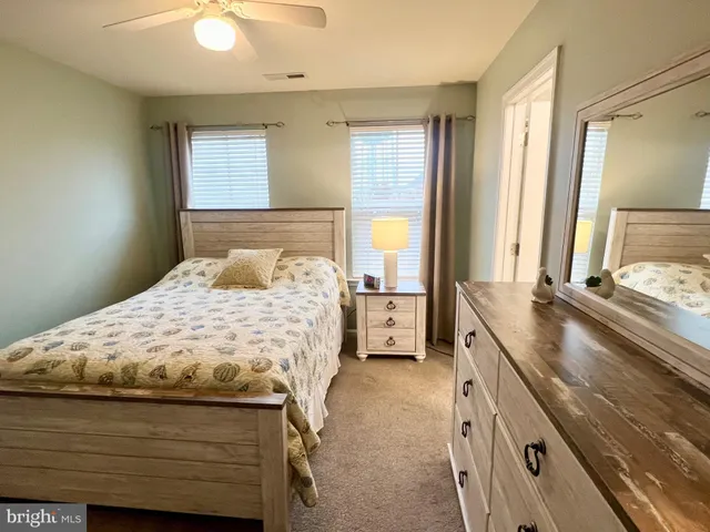 a bedroom with a bed and a large mirror on the dresser