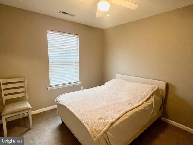 a bed sitting in a bedroom next to a window