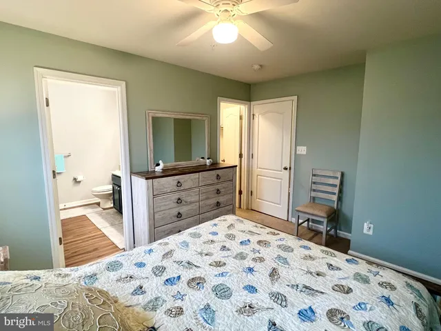 a kitchen with stainless steel appliances white cabinets and a stove a refrigerator with wooden floor