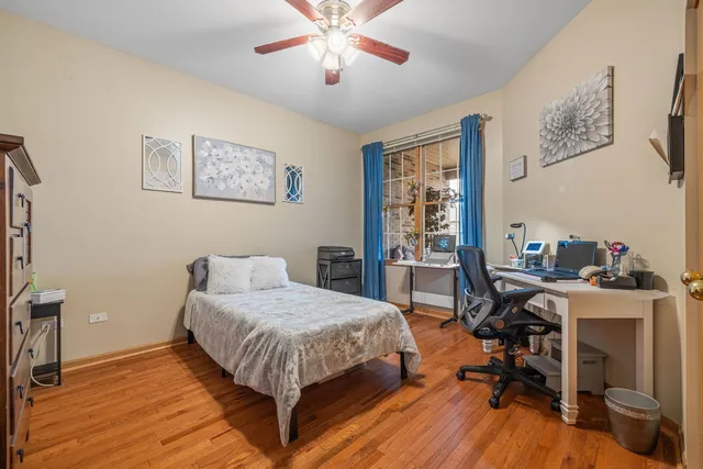a view of empty room with wooden floor and fan