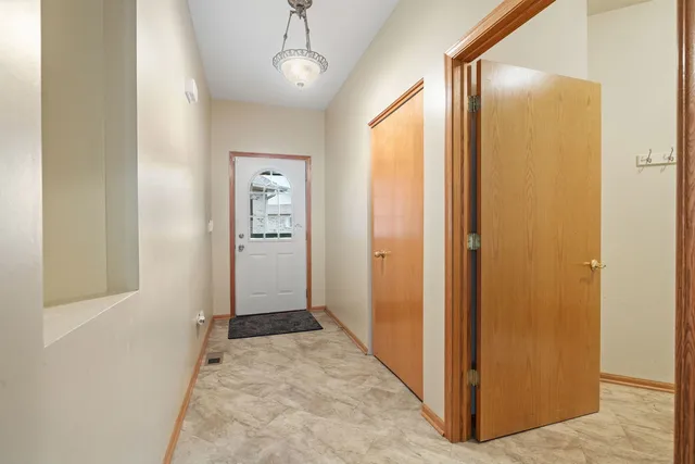 a view of a hallway with wooden floor and closet area