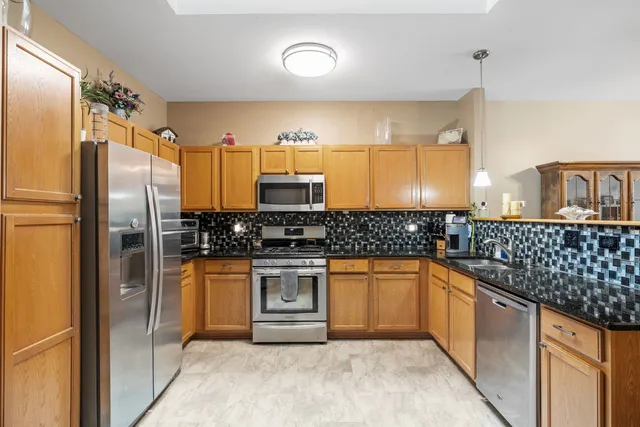 a kitchen with stainless steel appliances granite countertop a sink stove and refrigerator