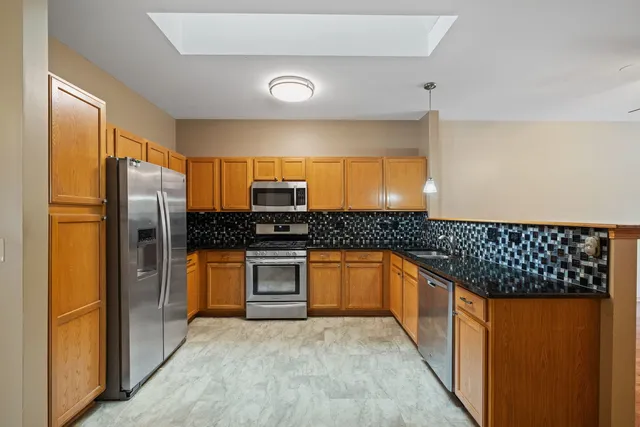 a kitchen with stainless steel appliances granite countertop a refrigerator and a sink