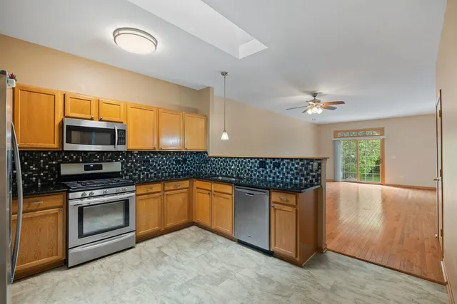 a kitchen with stainless steel appliances granite countertop a stove a sink and a microwave