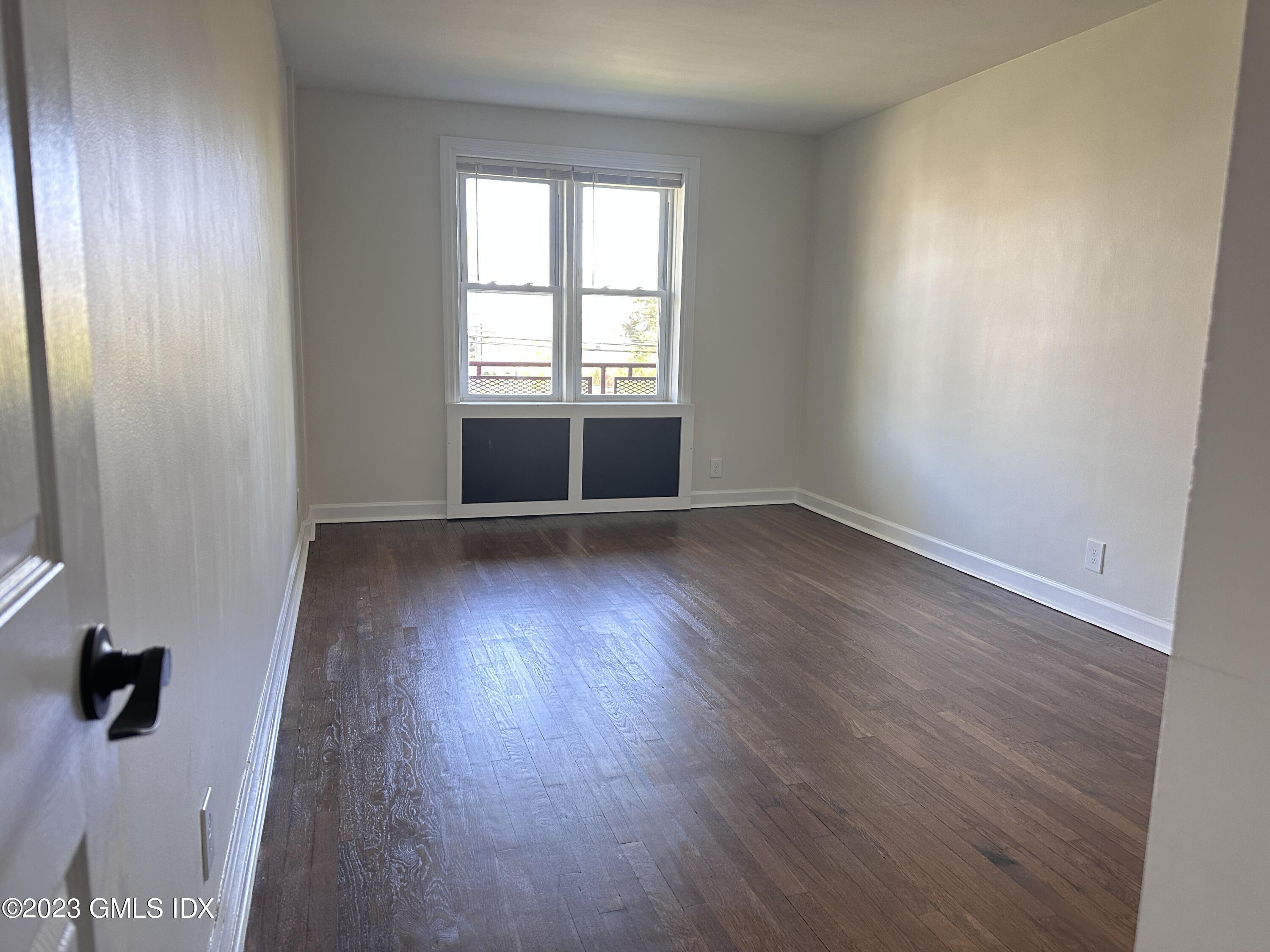 20 Brookside Drive, Unit 3D Greenwich, CT 06830 - Photo 9 of 24 an empty room with wooden floor and windows