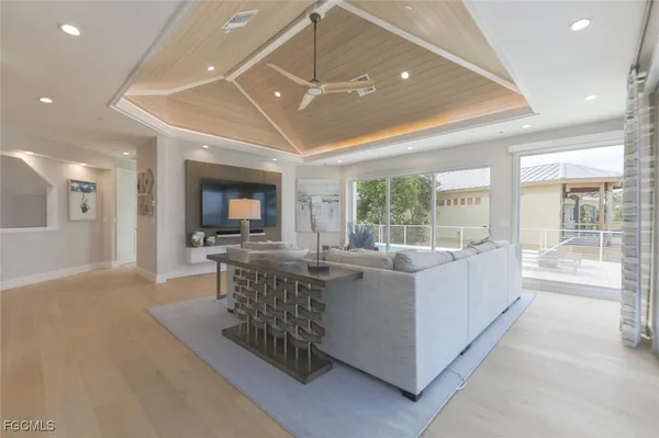 a living room with furniture a flat screen tv and a large window