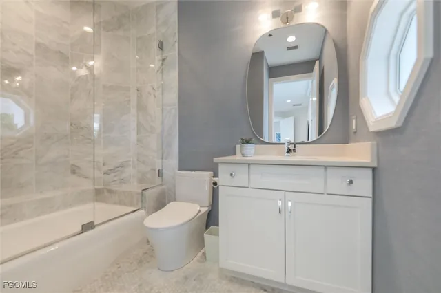 a bathroom with a bathtub shower sink vanity and toilet