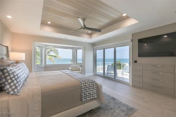 a bedroom with a large bed and a flat tv screen on dresser