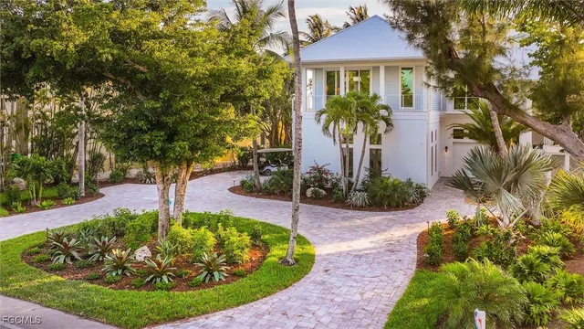 a view of a house with a yard and potted plants