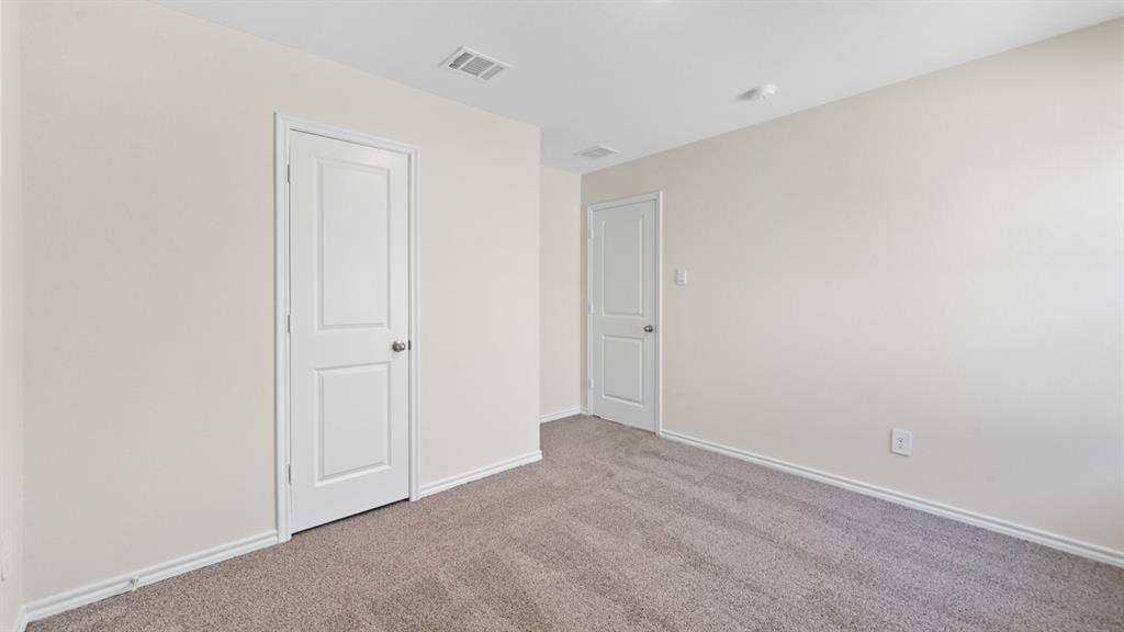 657 Glee Stem Road Lavon, TX 75166 - Photo 19 of 26 Carpeted interior room featuring light-toned walls, white trim, and two paneled doors with spherical hardware