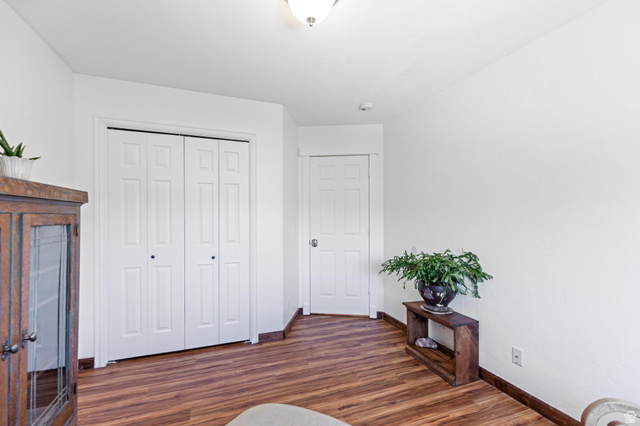 814 Mountain Road Logan, UT 84321 - Photo 16 of 42 Room featuring wood-finish flooring, white walls, white trim, and a white bi-fold closet door