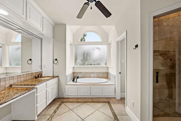 a spacious bathroom with a sink a large mirror and a bathtub