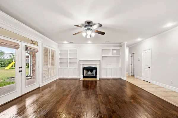 a room with wooden floor and a book shelf