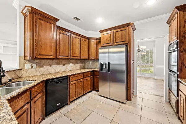 a kitchen with stainless steel appliances granite countertop a refrigerator and a stove top oven