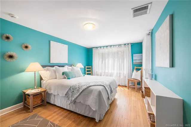 a bedroom with a bed and a dresser next to a window