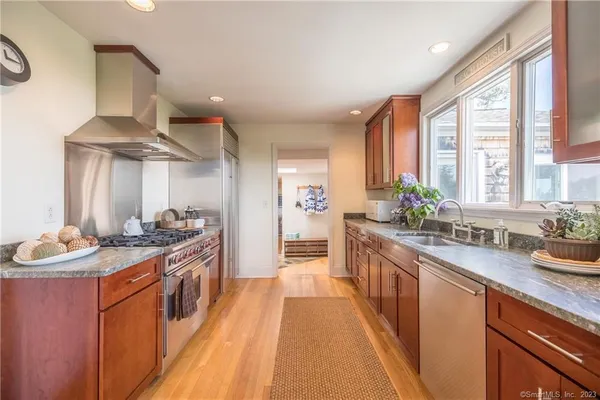 a kitchen with stainless steel appliances a sink stove and cabinets