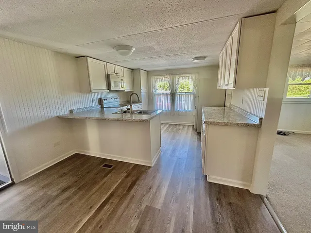 a kitchen with stainless steel appliances granite countertop a sink stove and wooden floor