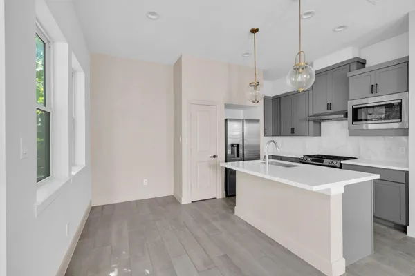 a kitchen that has a lot of cabinets a sink and a stove