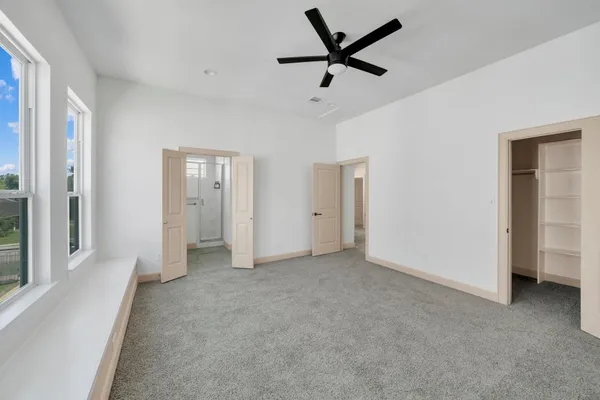 an empty room with a ceiling fan and window