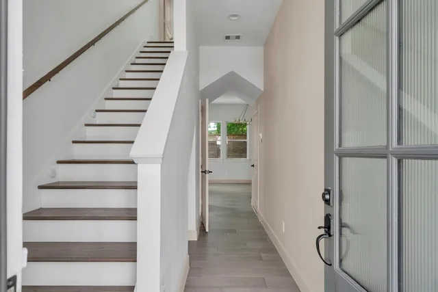 a view of hallway with stairs and wooden floor
