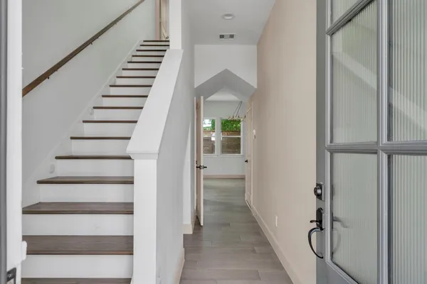 a view of hallway with stairs and wooden floor