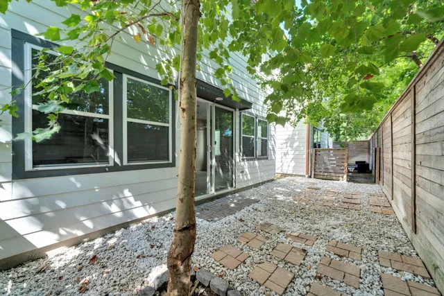 a view of a house with a tree in the backyard