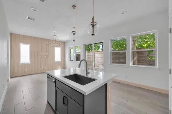 a kitchen that has a sink a window and cabinets