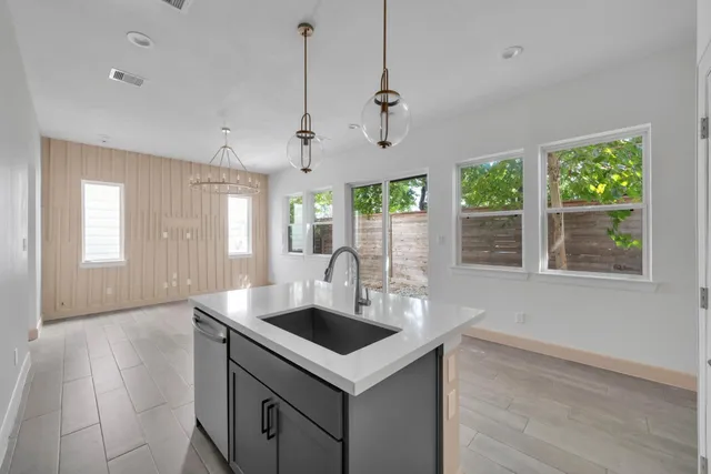 a kitchen that has a sink a window and cabinets