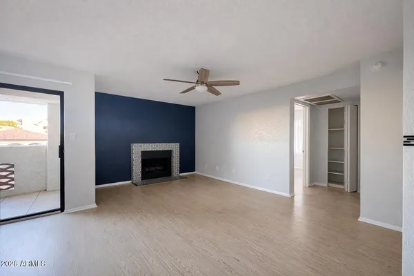 an empty room with windows and a fireplace